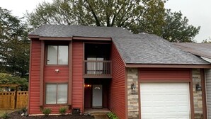 A two-story house with a red exterior, a front porch, and a garage. - You're going to love it here! (Virginia Beach)