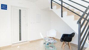 A modern apartment with a glass table, two chairs, a staircase, and a door marked "APARTMAN". - Villa Maja (Konavle)