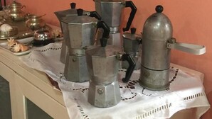 A collection of vintage kitchen appliances on a table with a white lace tablecloth. - Pousada Nel Blu (Itaparica)