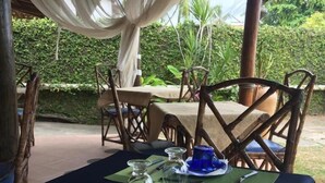 A table set with blue dinnerware, green placemats, and a clear glass. - Pousada Nel Blu (Itaparica)