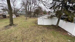 A residential backyard with a white shed, a tree, and a house in the background. - Beaumont Nurses or Dr’s need quarantine site?<br>Downtown Royal Oak, charming 2bd (Royal oak)