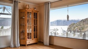 Ein Zimmer mit einem Holzschrank, Blick auf eine Brücke und eine Berglandschaft.