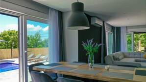 A modern dining area with a large table, chairs, and a vase of flowers. - Beautiful home in Glavina Gornja (Glavina Gornja)