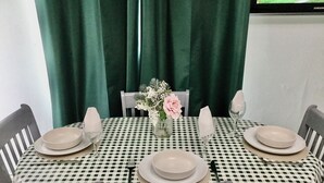 A dining table set with plates, glasses, and a vase with flowers. - COZY FARMHOUSE COTTAGE with wonderful views, FREE Fibre Broadband (Cappawhite)