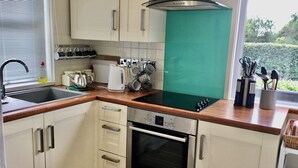 A modern kitchen with white cabinets, a Bosch oven, and a green backsplash. - COZY FARMHOUSE COTTAGE with wonderful views, FREE Fibre Broadband (Cappawhite)