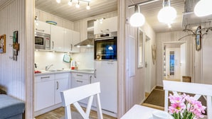 A modern kitchen with white cabinetry, stainless steel appliances, and pendant lighting. - Nice home in OstseeResort Olpenitz with sauna (OstseeResort Olpenitz)