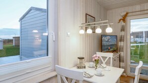 A cozy room with a white table, a television, and a window overlooking a grassy area. - Nice home in OstseeResort Olpenitz with sauna (OstseeResort Olpenitz)