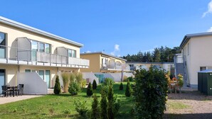 A row of modern, two-story buildings with balconies, a well-maintained lawn, and a clear blue sky. - Nice apartment in Graal-Müritz with WiFi (Graal-Müritz)