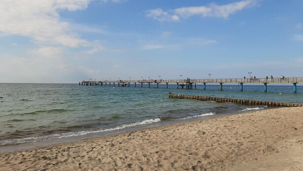 A beach with a wooden pier extending into the water, featuring a sandy shore and clear skies. - Nice apartment in Graal-Müritz with WiFi (Graal-Müritz)