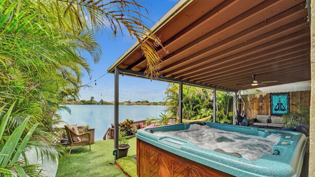 Ein Whirlpool unter einer Holzpergola mit Seeblick.