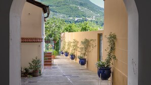 An arched corridor with potted plants and a view of a hillside. - Casa Assunta Sorrento Amalfi Coast, Vico Equense - free wifi (Vico Equense)