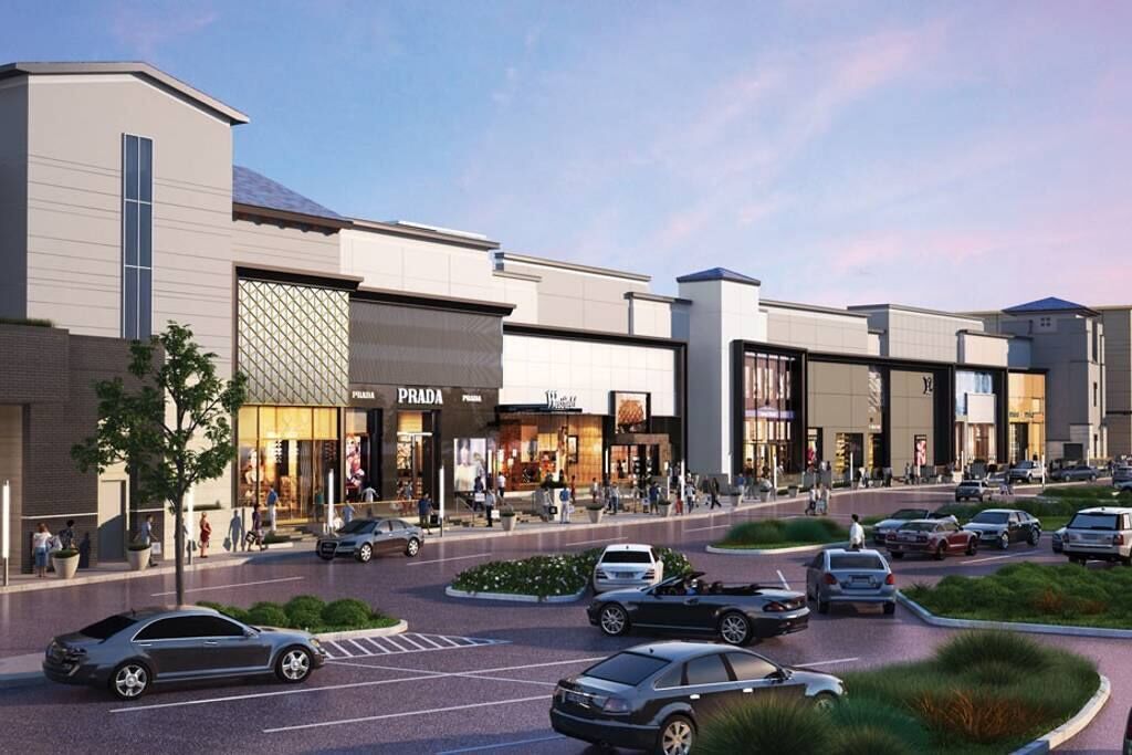 Um moderno centro comercial com várias lojas, incluindo Prada e H&M.