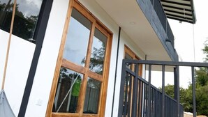 Un edificio moderno con ampie finestre, un balcone con ringhiera e un tetto piano.