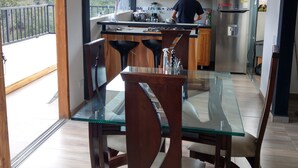 Una cucina moderna con mobili in legno, un tavolo da pranzo in vetro e vista sull'esterno.