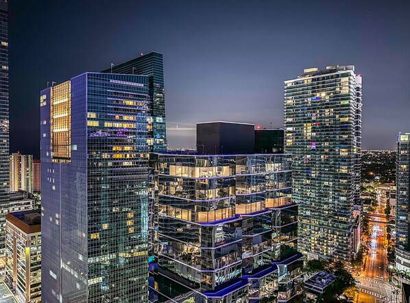 Un immeuble de grande hauteur, doté de nombreux étages et de balcons, et présentant un design architectural moderne avec des façades en verre.