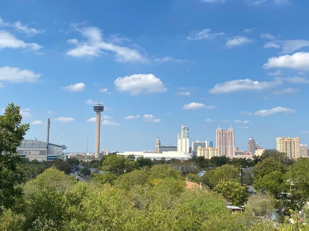 Une vue sur les toits d’une ville, avec une tour imposante et divers bâtiments.
