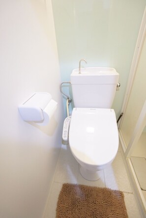 Bathroom features a toilet, bidet attachment, and tiled floor.