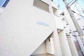 Stylish building with a minimalist design, featuring a striking Japanese sign.