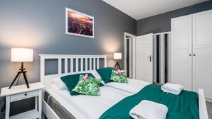Een keurig opgemaakt slaapkamer met een bed, nachtkastjes en een kledingkast.