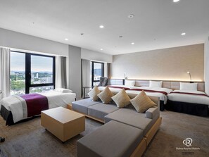 Relax in comfort with a large bed, sofa, and two smaller beds, all set against a stunning city view.