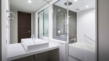 Un baño moderno con ducha envuelta en vidrio, un lavamanos blanco y una bañera.