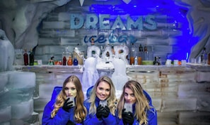 An ice bar with a 'Dreams' sign and a large ice sculpture of a bear.