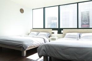 A bedroom with two beds, a large window, and a wall clock. - Sweet House (Seoul)