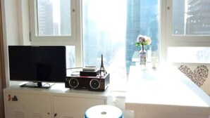 A room with a TV, a radio, and a small Eiffel Tower model on a cabinet. - Sweet House2 (Seoul)