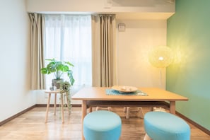 Enjoy meals in this cozy dining area with a table set for two, a potted plant, and a floor lamp.
