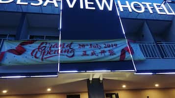 The exterior of the Desai View Hotel with a banner announcing the grand opening on 20th July 2019.