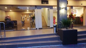 Eine Hotlellobby mit einer Rezeption, einer Treppe und einem Mülleimer.
