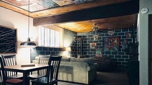 A cozy dining area with a table and chairs, a sofa, and a ceiling fan. - Sunflower House near Skiing, boating and Apple Hill (Pollock Pines)