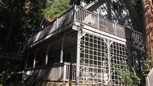 A two-story house with a balcony and a large window with a grid design. - Sunflower House near Skiing, boating and Apple Hill (Pollock Pines)