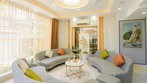 A modern living room with grey sofas, a round coffee table, and a painting on the wall. - Hera Hotel (Ho Chi Minh City)