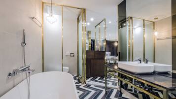 A modern bathroom with a freestanding bathtub, dual sinks, and a large mirror.