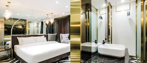 A modern hotel room with a large bed, a bathroom with a marble countertop, and a mirror with gold accents.