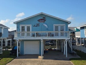 A two-story building with a blue exterior, a balcony, and a garage.