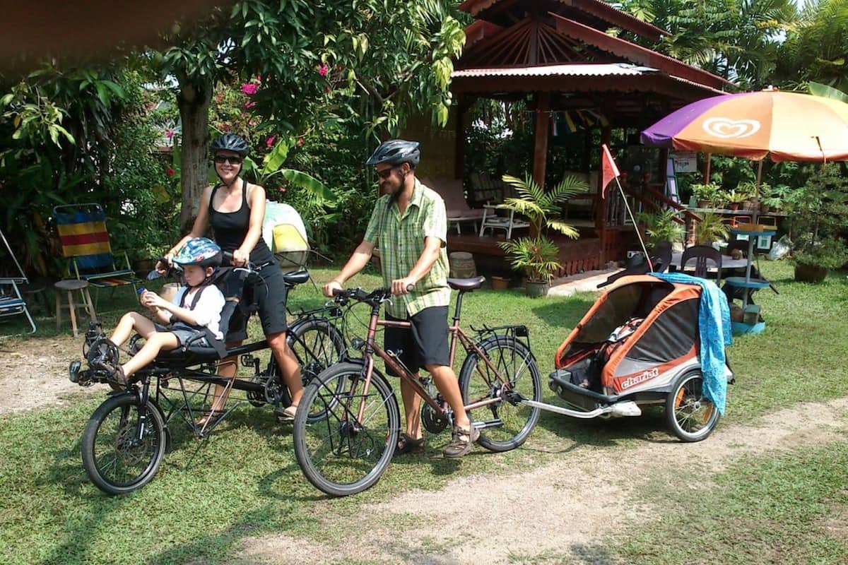 A garden with a gazebo, a stroller, and bicycles.