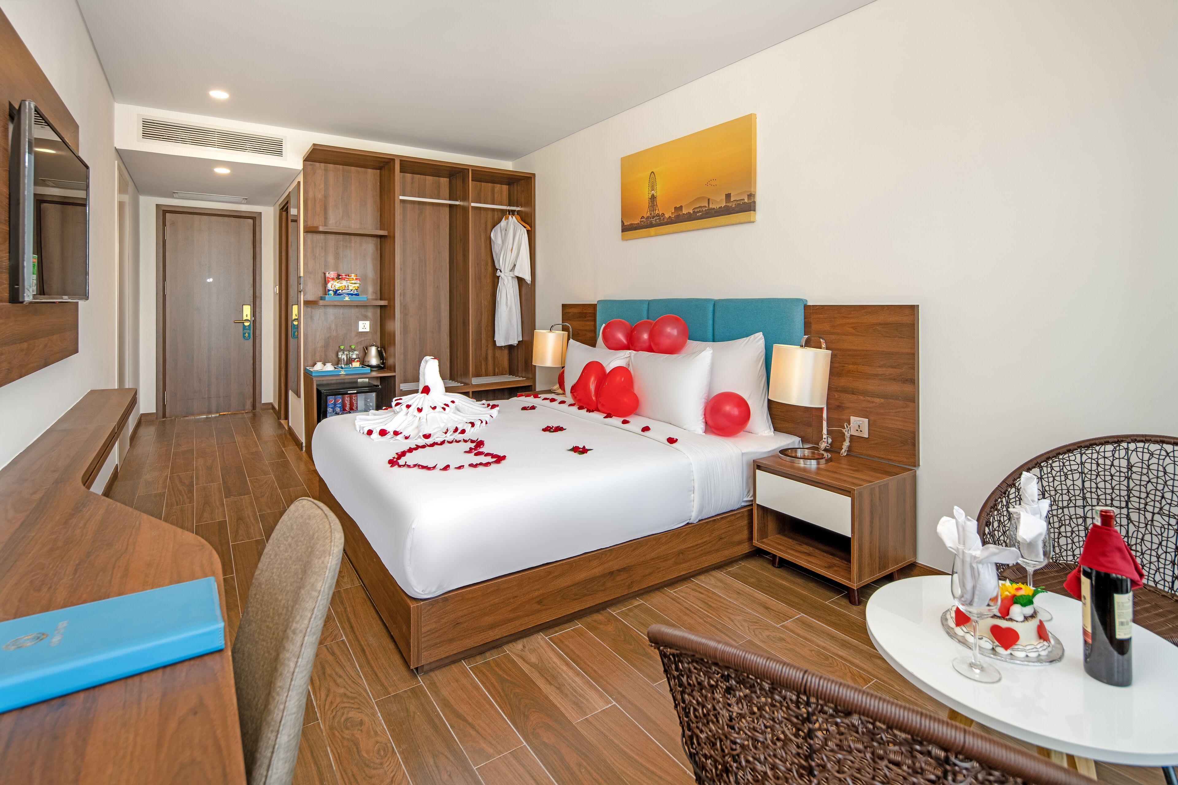 Habitación de hotel con una cama grande, armario de madera, una mesa de comedor y una silla.