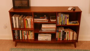 Ein Bücherregal aus Holz mit Büchern und einem alten Radio.