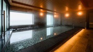 A modern indoor swimming pool with a tiled floor, wooden ceiling, and large windows allowing natural light. - Keikyu EX INN Haneda Innovation City (Tokyo)