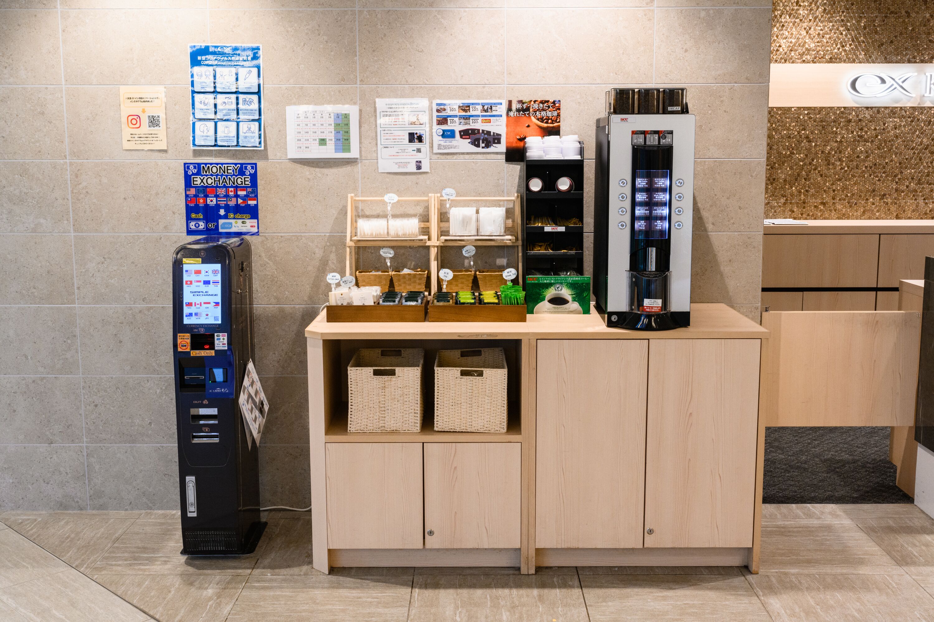 A money exchange machine, a refrigerator, and a wooden counter with baskets and towels.