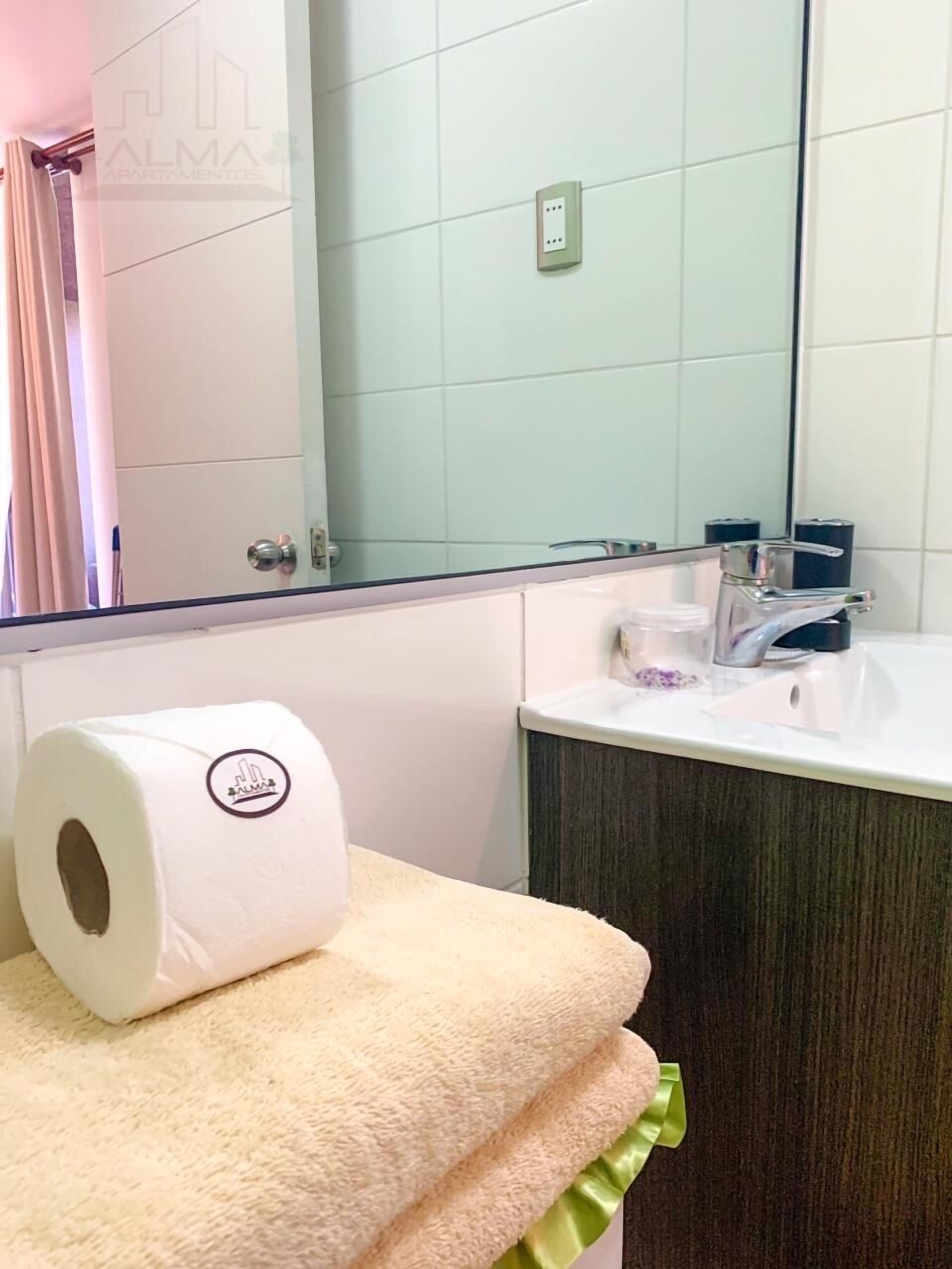 A bathroom with a white sink, a mirror, and a towel rack with a towel.