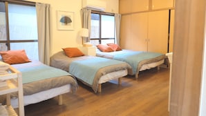 A room with two single beds, a wardrobe, a bedside table with a lamp, and a window with curtains. - Nagomiya Kyoto Gion (Kyoto)