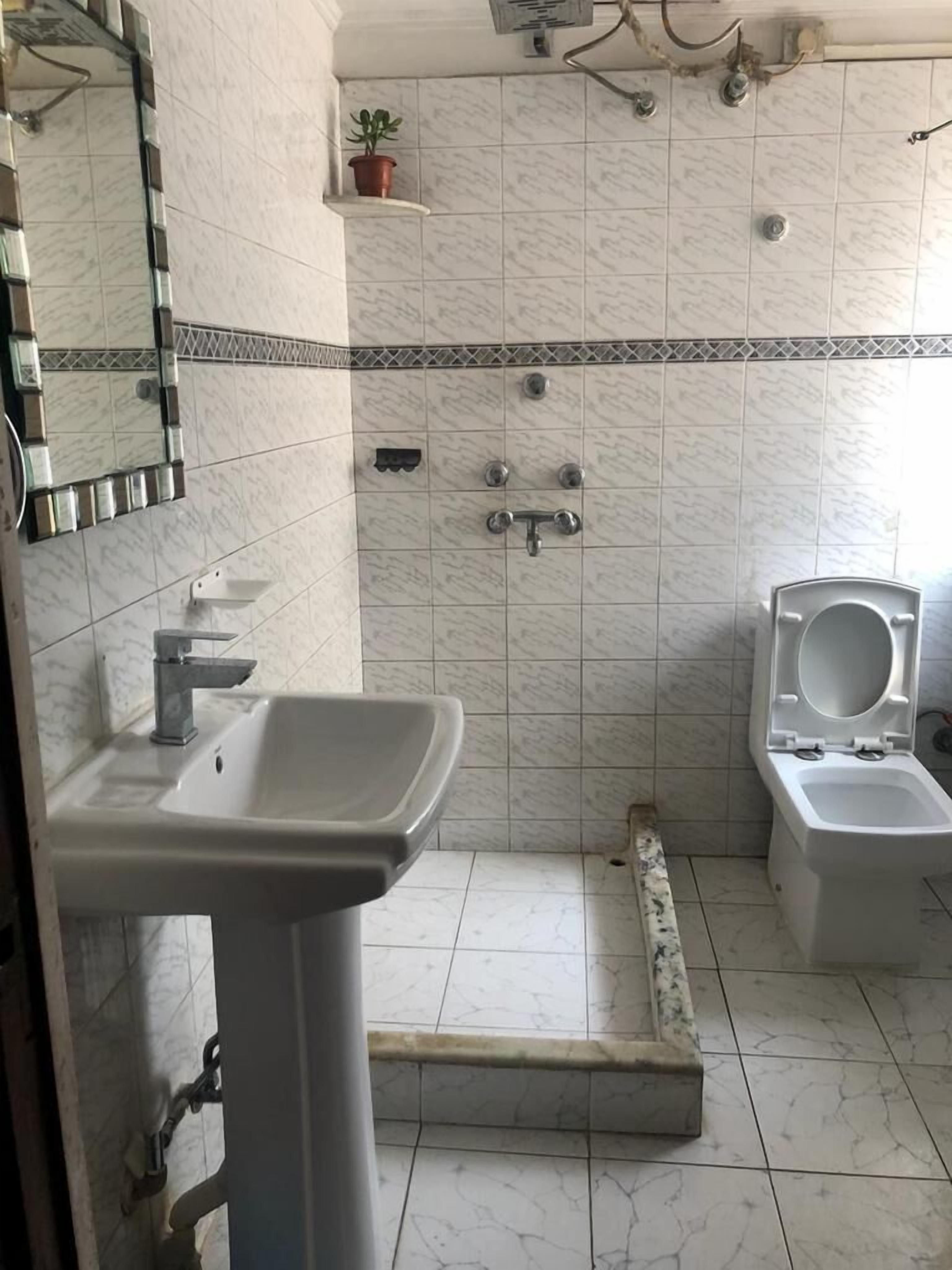 Une salle de bain comprenant un lavabo, des toilettes et un espace douche.