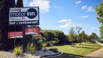 A sign for Bristol Hill Motor Inn Peppa's bar & restaurant, indicating amenities like a swimming pool, heated indoor spa, and free WiFi.