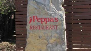 Un letrero de piedra grande con el texto 'Peppas Restaurant' en letras rojas.