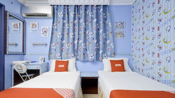 A hotel room with two beds, a desk, and a chair. - OYO 89958 Hotel Umimas (Lahad Datu)