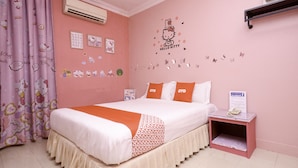 A pink-themed bedroom with a bed, pillows, a nightstand, and a wall decal. - OYO 89958 Hotel Umimas (Lahad Datu)