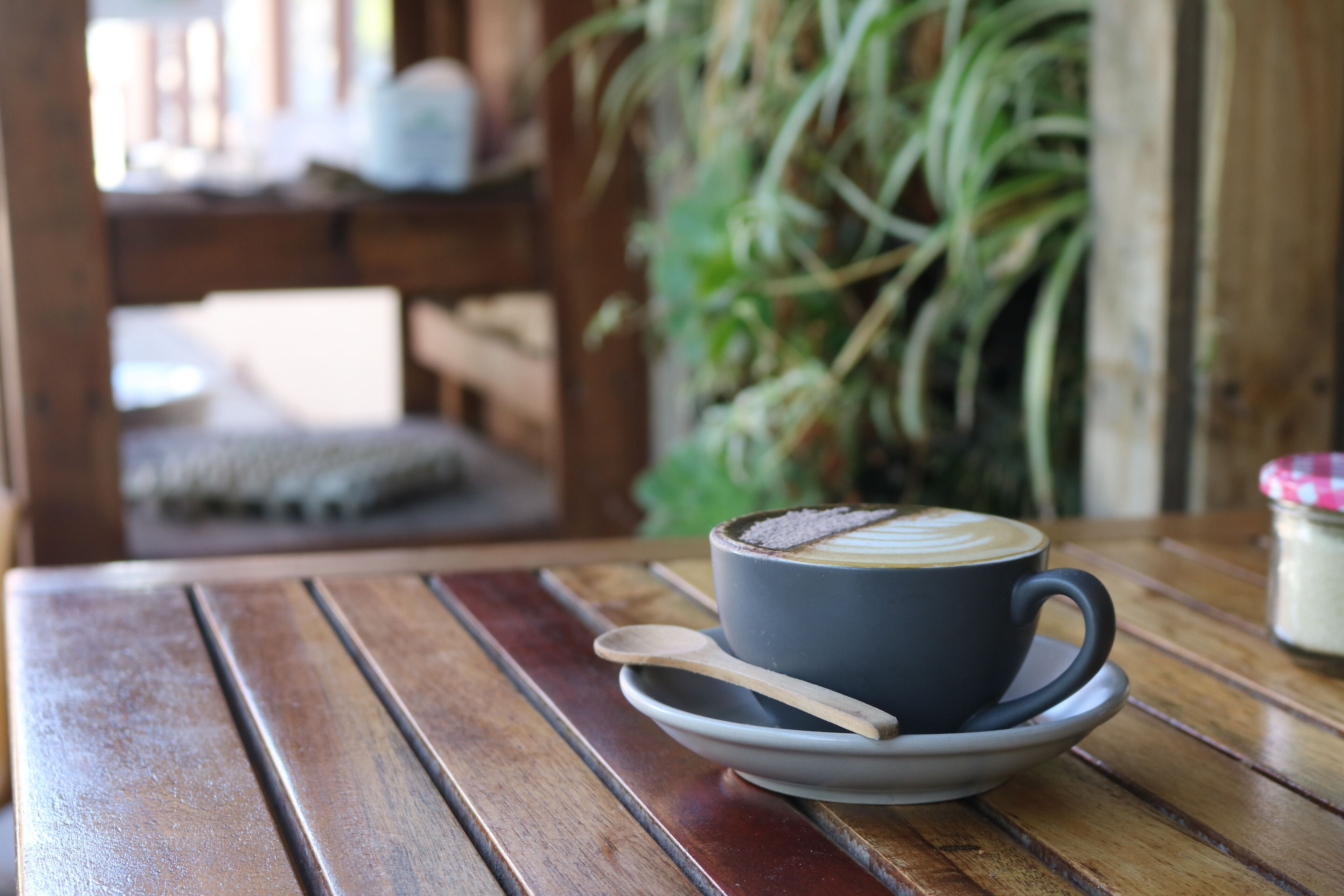 Een houten tafel met een kop koffie en een schoteltje.